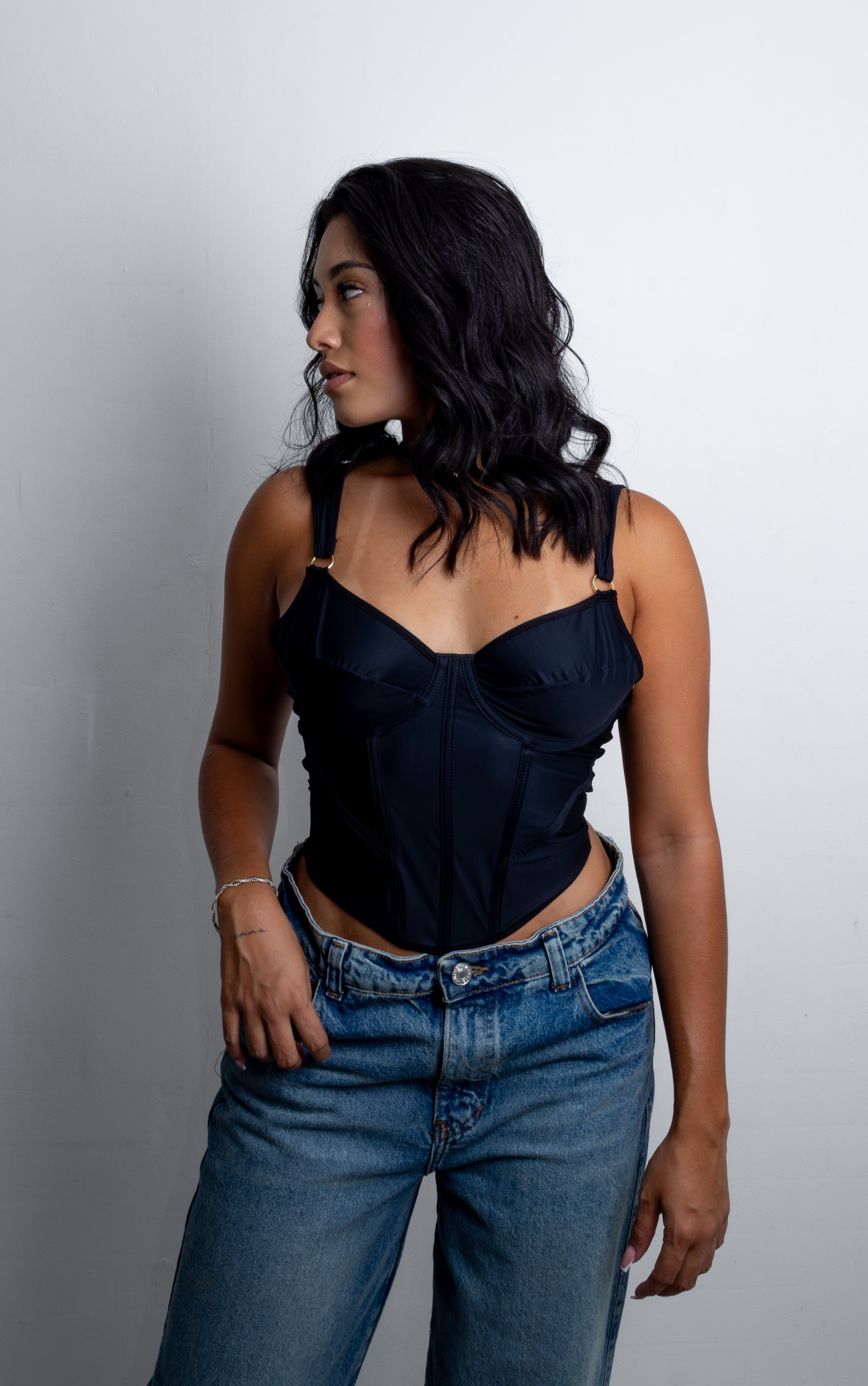 Mujer luciendo el Corset Leslie estructurado con varillas, copas y sistema de amarrado en la espalda descubierta.