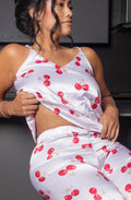 Dale un toque dulce y femenino a tus noches con la Pijama Jolie, un conjunto de dos piezas con acabado satinado y delicado estampado de cerezas. Su top de tirantes ajustables y pantalón de pierna amplia crean una silueta cómoda, fresca y estilizada, perfecta para descansar con mucho estilo.