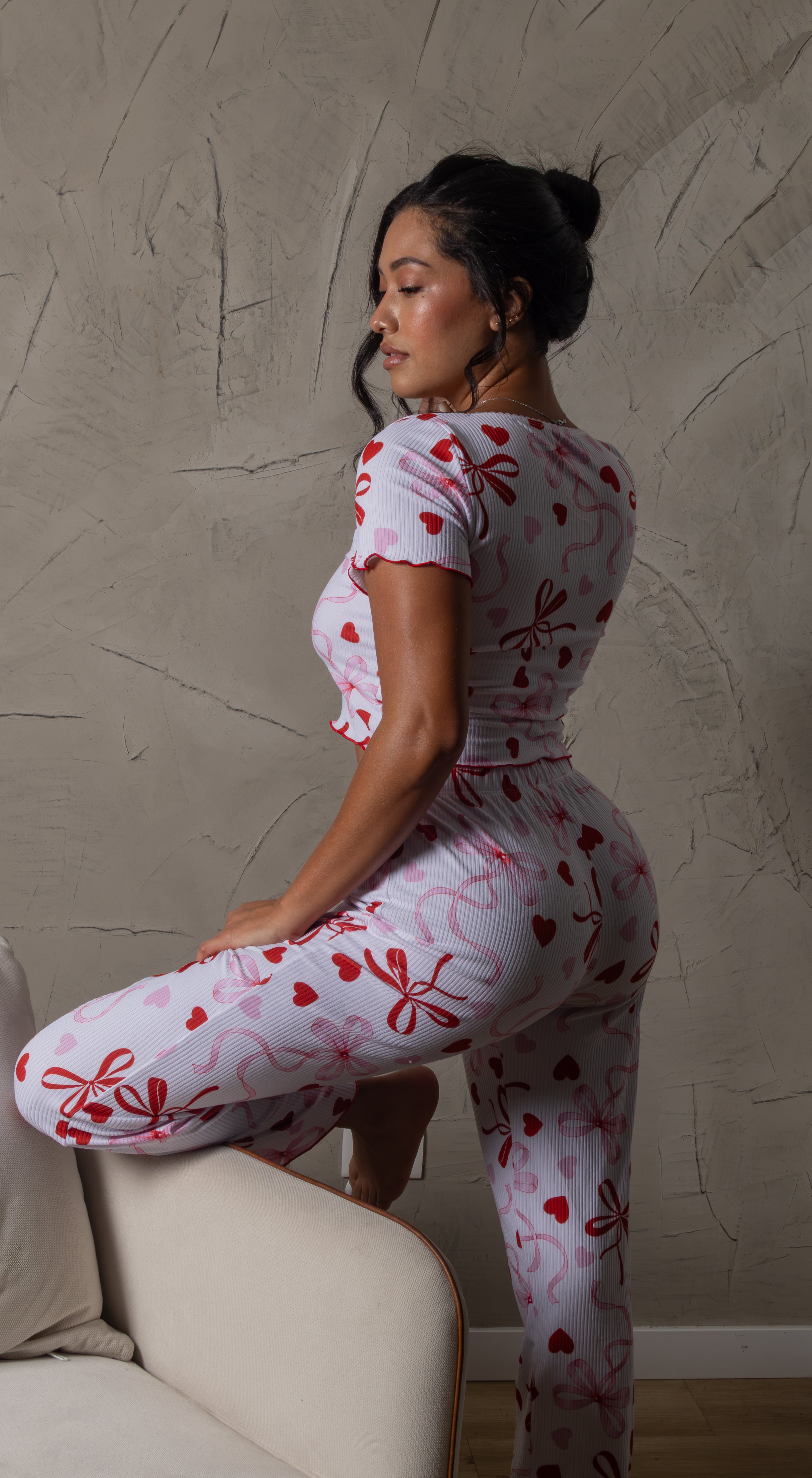 El Pijama Melisande combina un diseño divertido y femenino con el confort que buscas para tus momentos de descanso. Su base blanca de textura acanalada está decorada con estampados de Hello Kitty, moños y detalles en rojo y azul. Incluye un top de manga corta con botones frontales y pantalón largo a juego, creando un conjunto ideal para relajarte con mucho estilo.