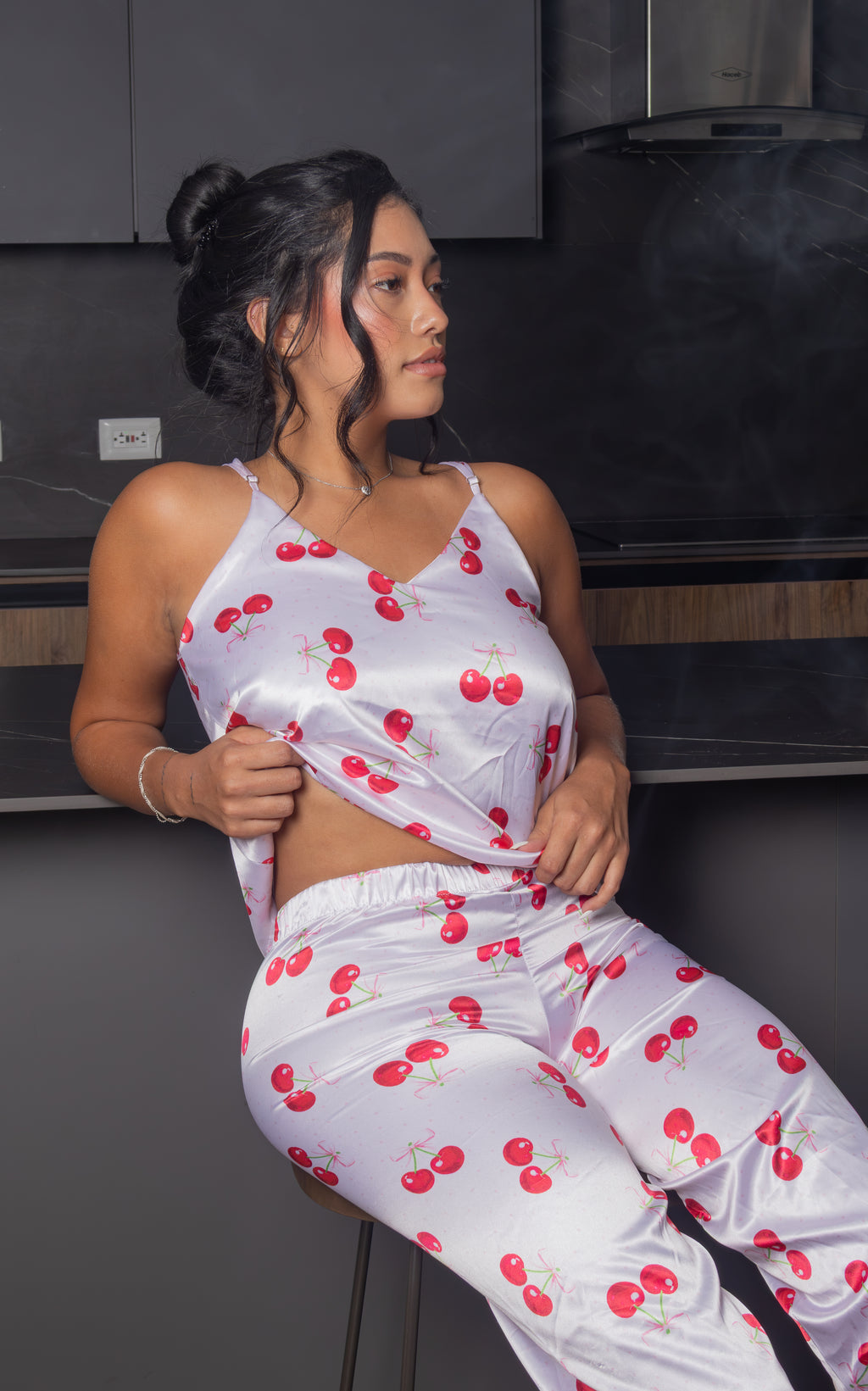 Dale un toque dulce y femenino a tus noches con la Pijama Jolie, un conjunto de dos piezas con acabado satinado y delicado estampado de cerezas. Su top de tirantes ajustables y pantalón de pierna amplia crean una silueta cómoda, fresca y estilizada, perfecta para descansar con mucho estilo.